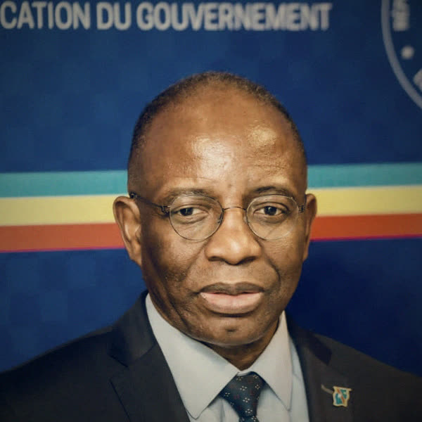 Portrait du ministre d'État à la Justice, devant un fond aux couleurs du drapeau de la République démocratique du Congo.